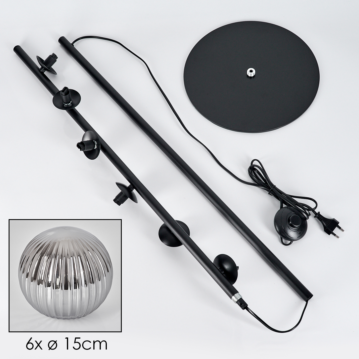 Komponenten einer schwarzen Stehlampe: Fuß, Stangen und eine graue, geriffelte Glaskugel. Drähte und Schalter.