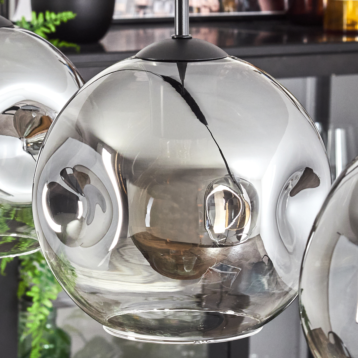 Nahaufnahme einer rauchigen Glaskugel mit einer warmen Glühbirne. Das Glas hat ein wellenförmiges Muster.