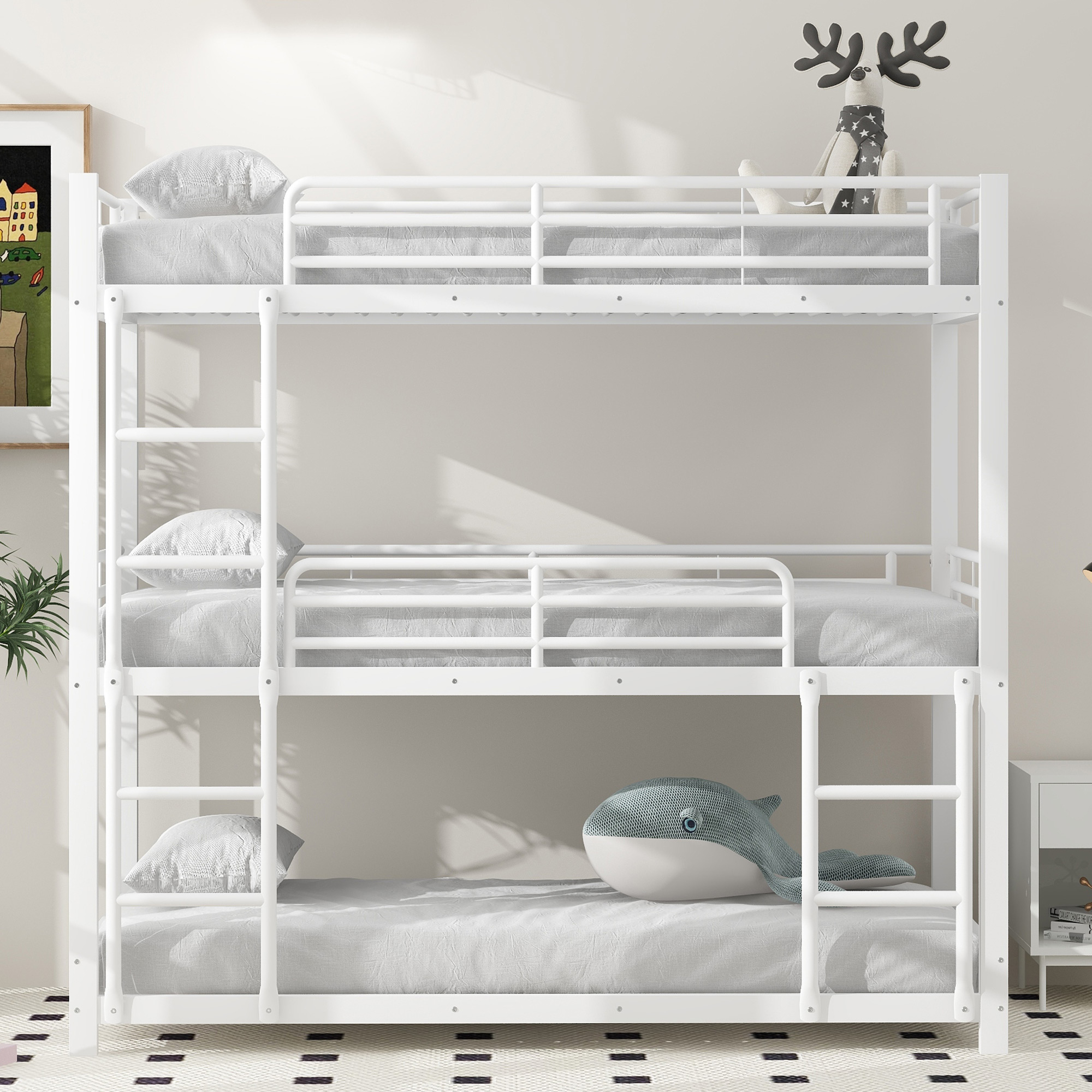 Ein Dreifach-Etagenbett vor einer weißen Wand. Kissen und ein Stoffwal befinden sich auf dem oberen Bett.