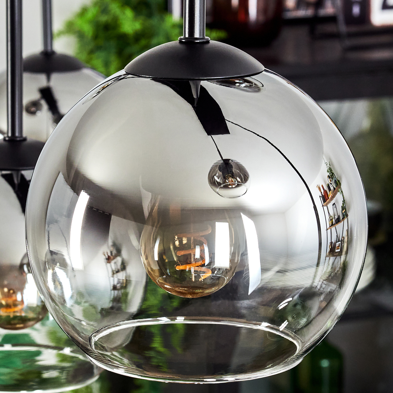Nahaufnahme einer Deckenlampe mit grauer Glaskugel und Glühbirne.