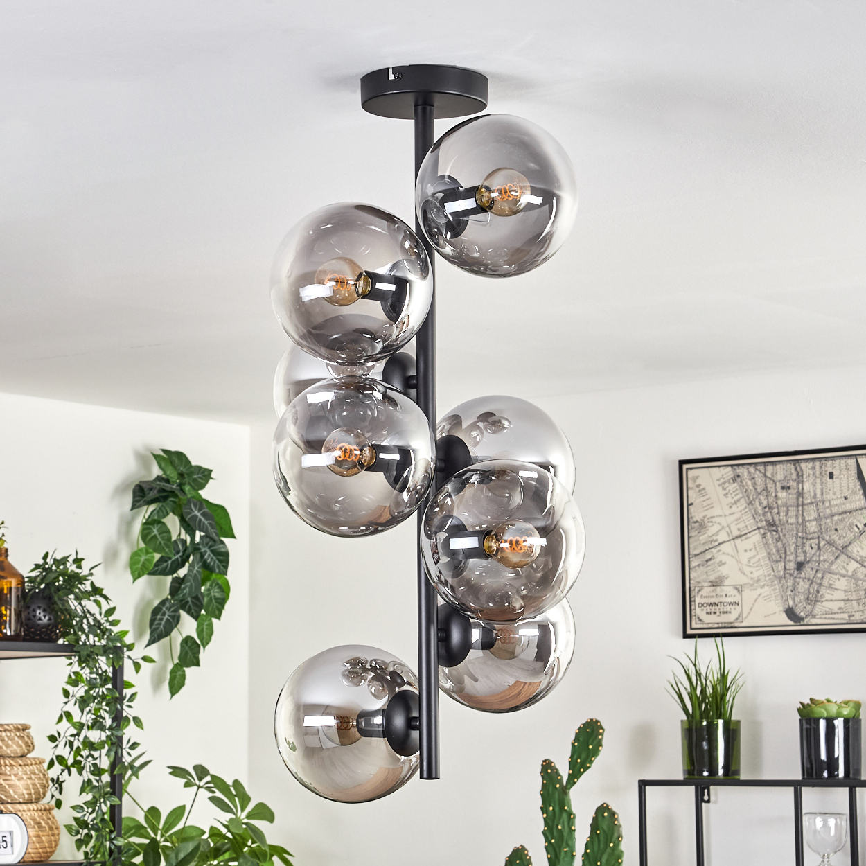 Eine schwarze Deckenlampe mit neun transparenten grauen Glaskugeln, jede mit einer Glühbirne.