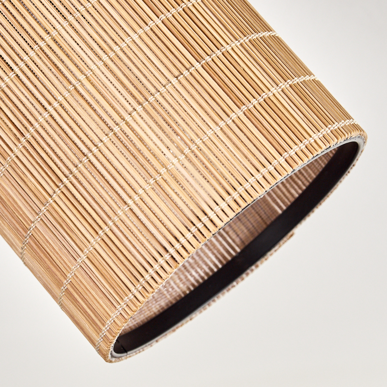 Nahaufnahme eines Rattan-Lampenschirms mit schwarzem Rand, der die Textur und das Geflecht zeigt.