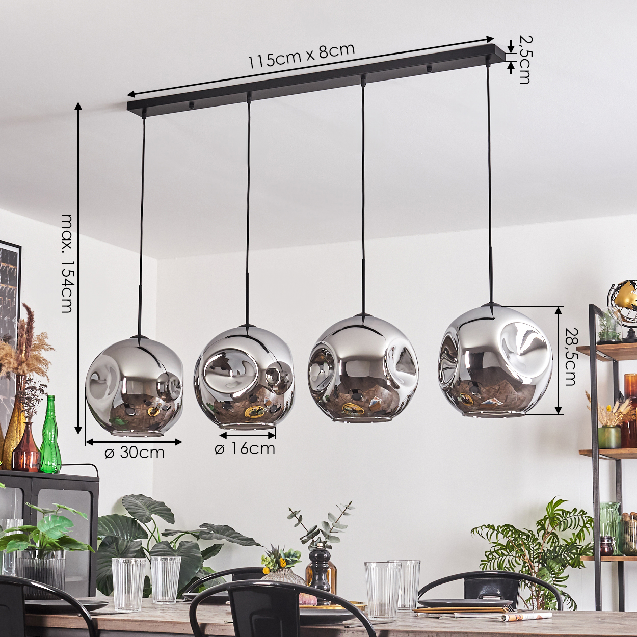Ein Esszimmer mit vier Pendelleuchten. Die Lampen sind silberne Kugeln mit einem schwarzen Balken. Abmessungen werden angezeigt.