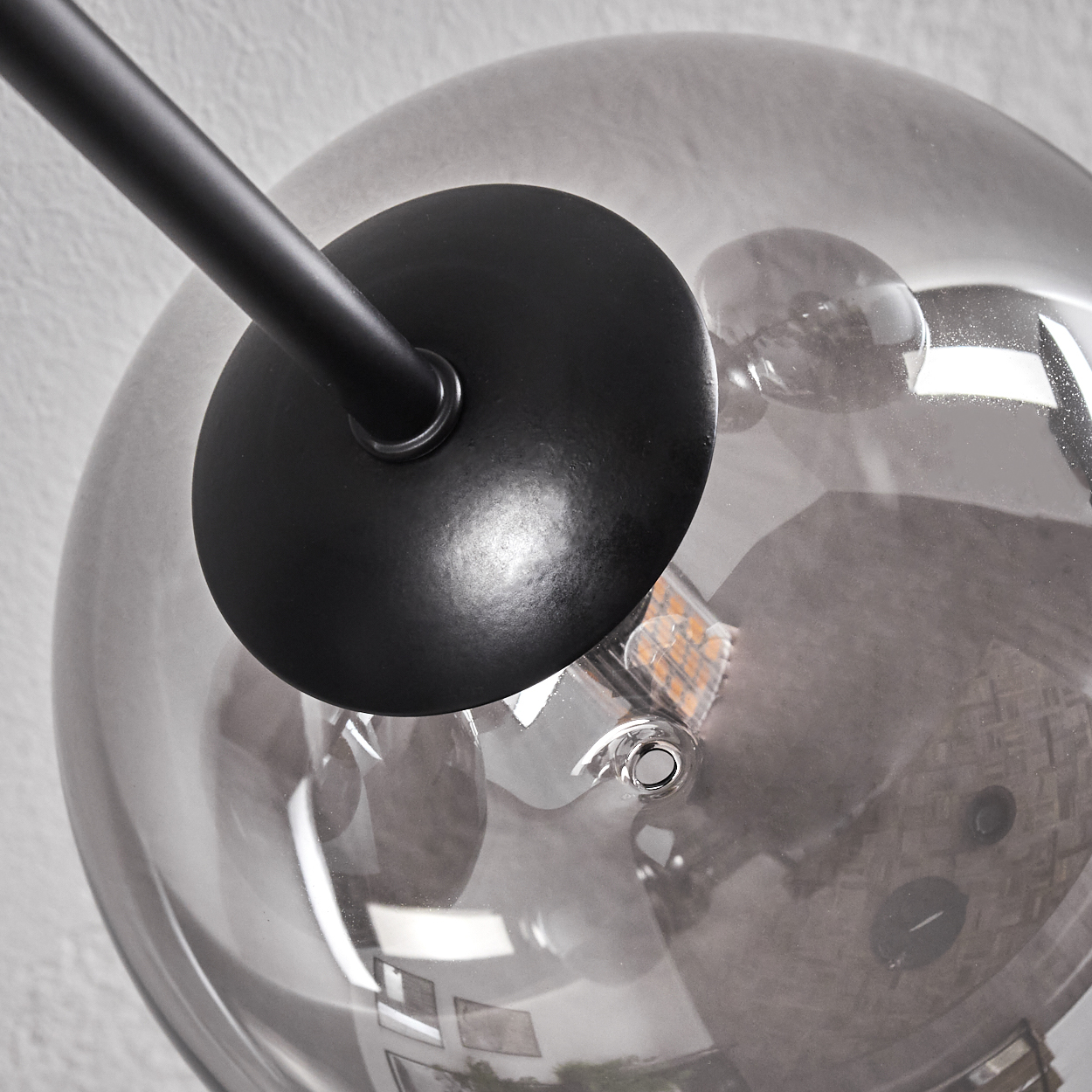 Nahaufnahme einer schwarzen Lampenkomponente mit einer Glühbirne in einem transparenten Globus.