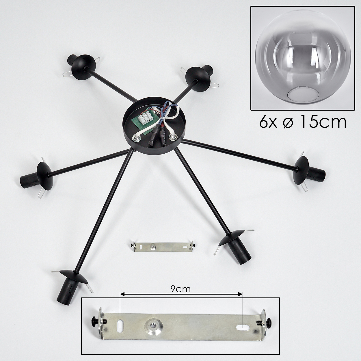 Montageteile für eine Deckenlampe. Die Teile sind schwarz und silber. Weißer Hintergrund.