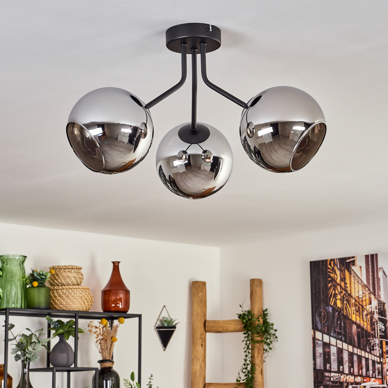 Eine Deckenlampe mit drei grauen Kugeln, jede mit einer freiliegenden Glühbirne.