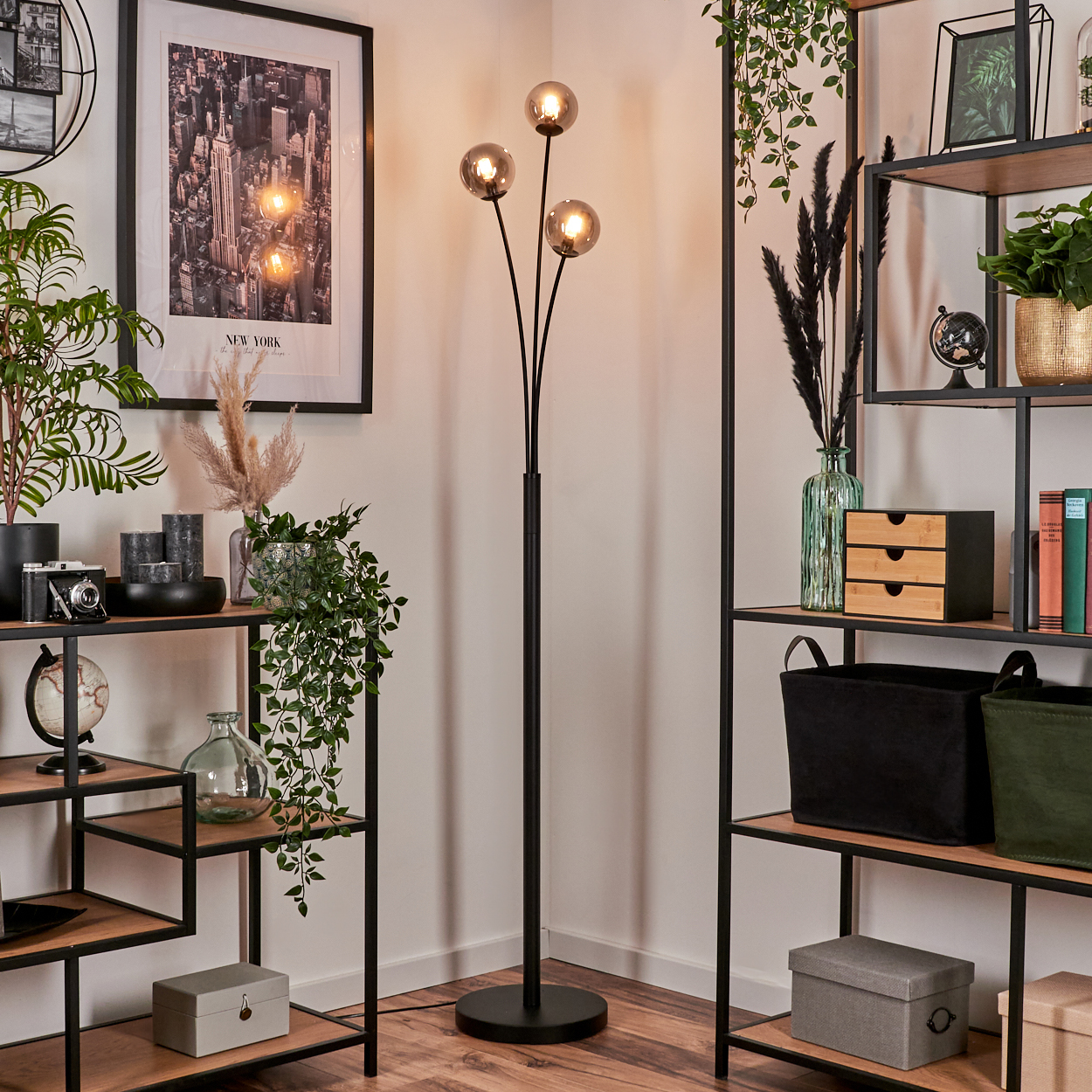 Ein Raum mit einer Stehlampe mit drei Kugeln und Regalen mit Dekorationen.