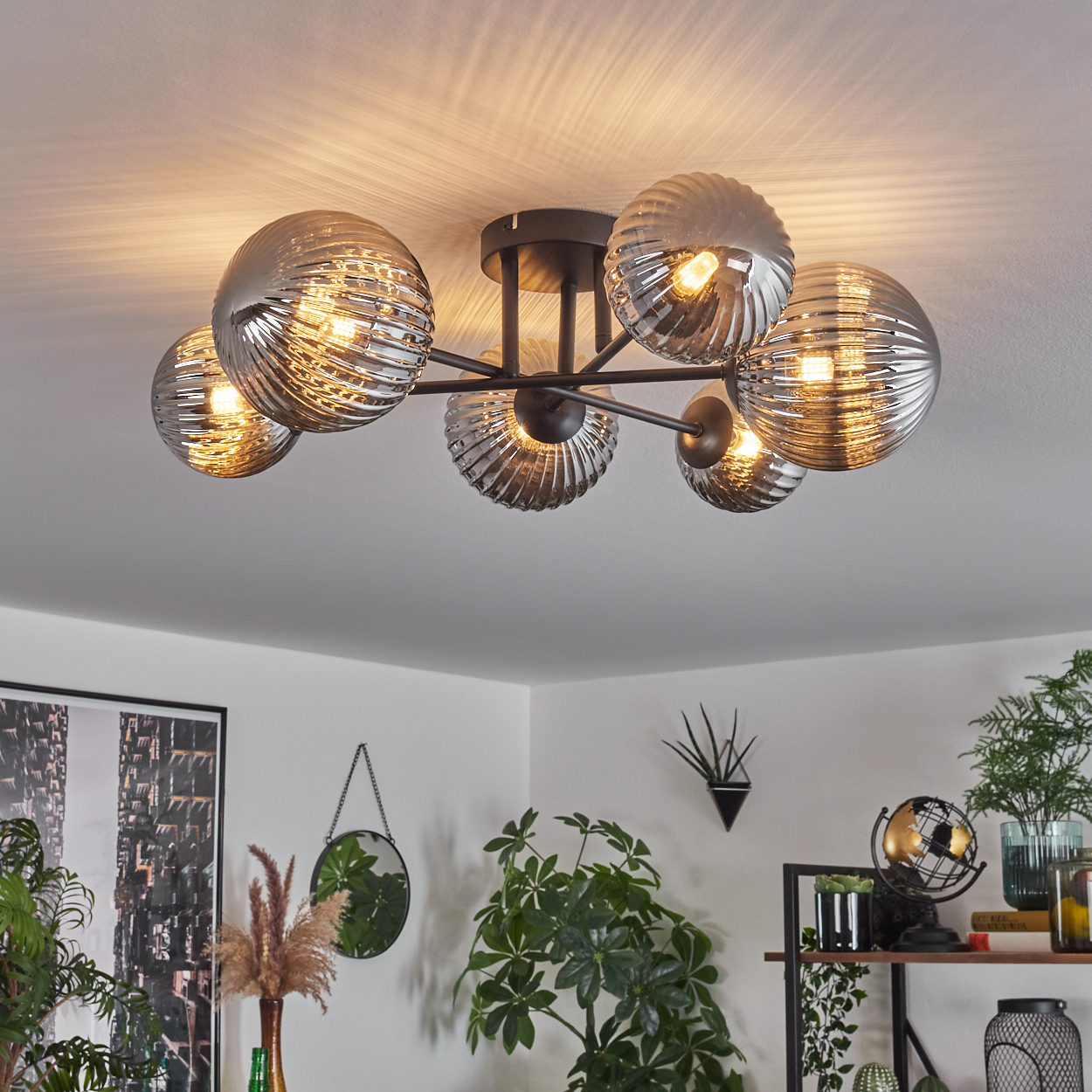Deckenlampe mit sechs gerippten Glaskugeln. Der Raum hat Pflanzen und Dekorationsartikel.