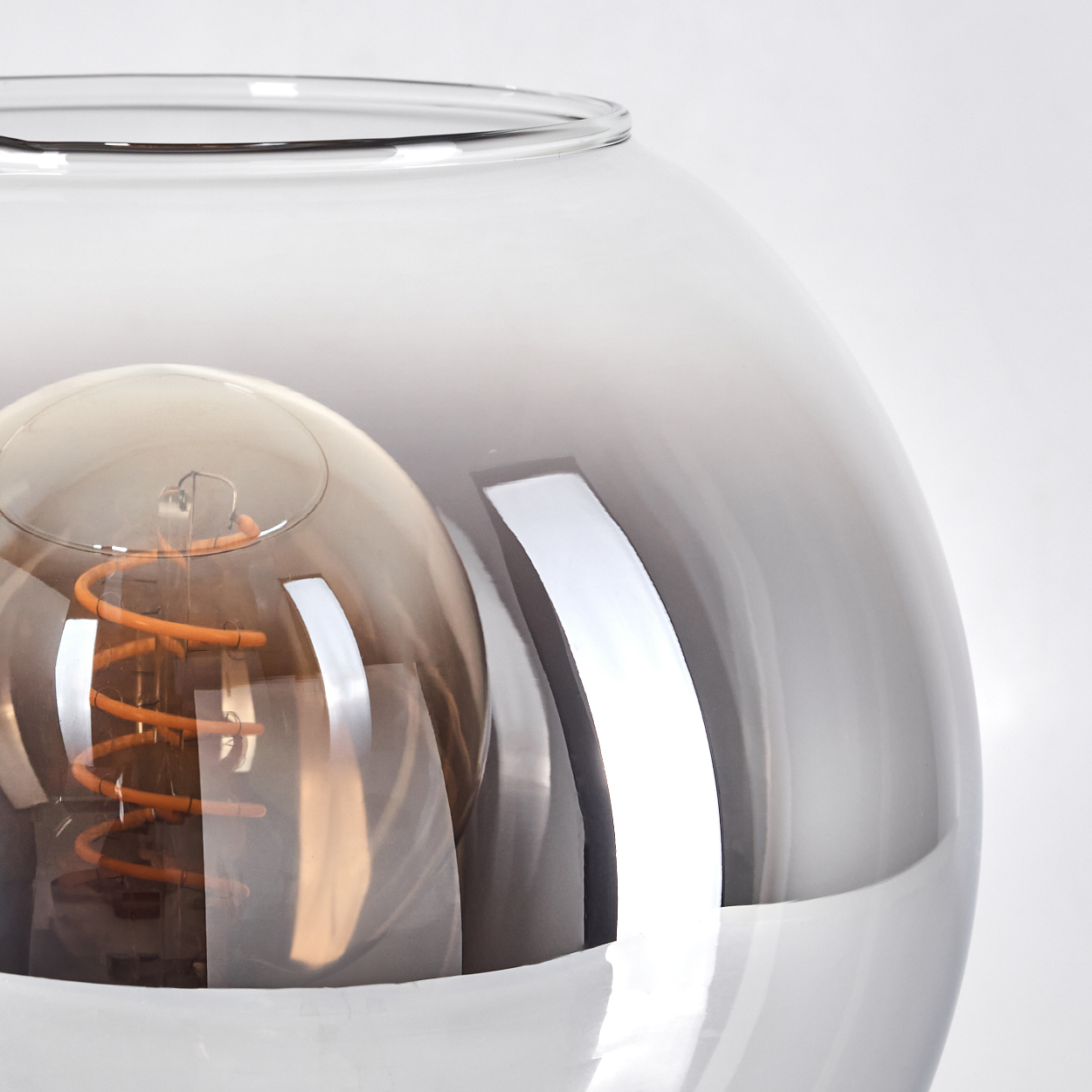 Eine Glaslampe mit einer Glühbirne. Es ist in transparentem Glas und hat einen weißen Hintergrund.