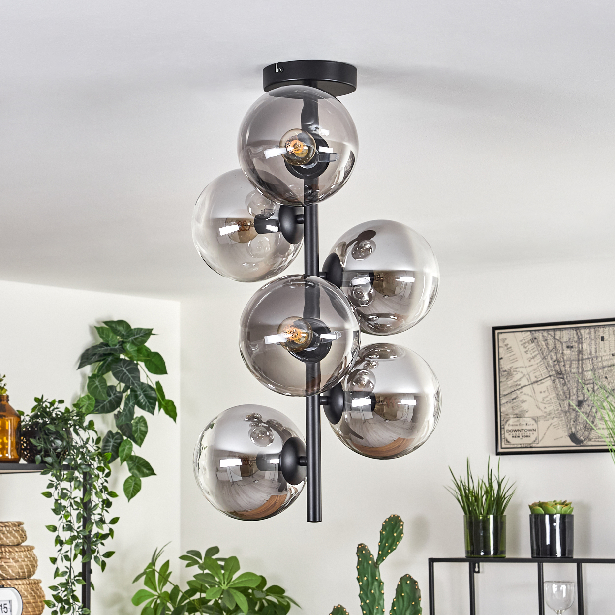 Eine Deckenlampe mit sieben grauen Glaskugeln. Schwarze Arme halten die Kugeln von einer schwarzen Basis aus.