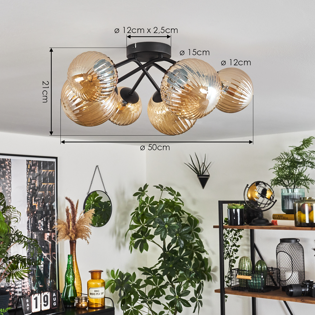 Deckenlampe mit goldenen Glaskugeln, Maße beschriftet. Die Lampe ist in einem Raum mit Pflanzen und Deko.
