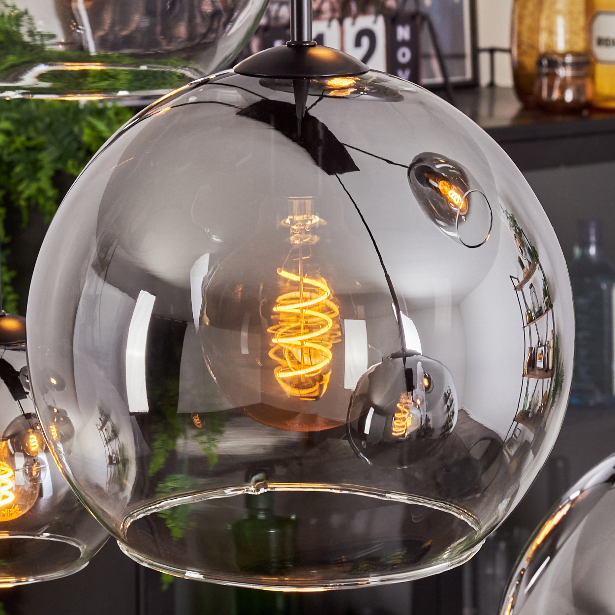 Nahaufnahme einer kugelförmigen Glaslampe mit einer Glühbirne im Inneren. Die Lampe hat eine reflektierende Oberfläche.