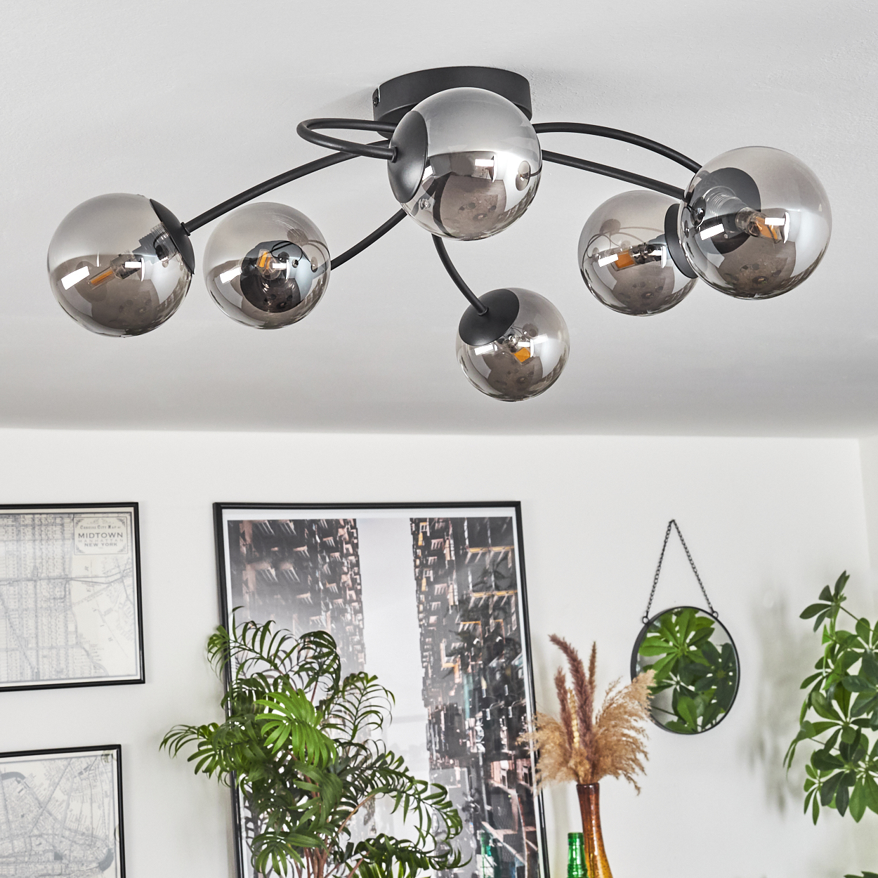 Eine Deckenlampe mit sechs kugelförmigen Glaslampen. Die Lampen sind in einem gebogenen, kreisförmigen Muster angeordnet.