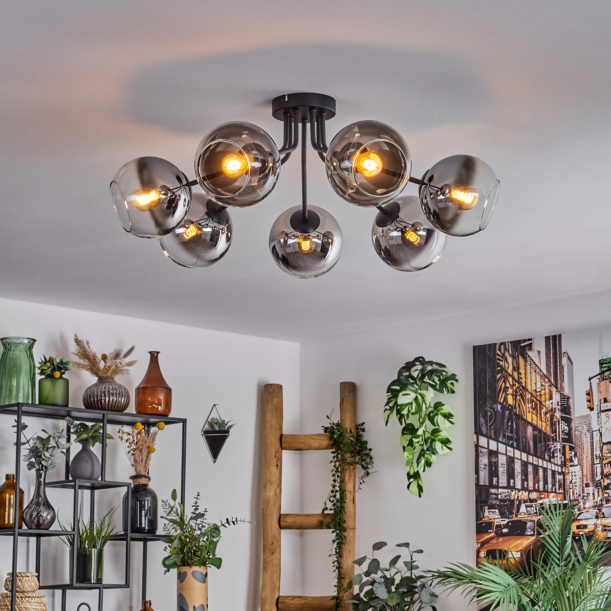 Deckenlampe mit sechs verspiegelten kugelförmigen Schirmen, beleuchtet von warmem Licht in einem Zuhause.