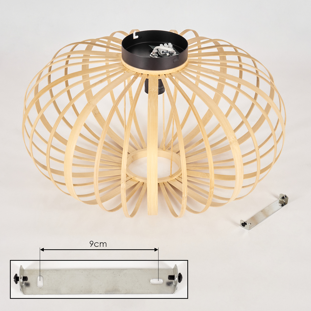 Eine hellfarbene Bambuslampe mit schwarzem Sockel. Neben der Lampe befindet sich eine Metallhalterung. Für die Halterung wird ein Maß angegeben.