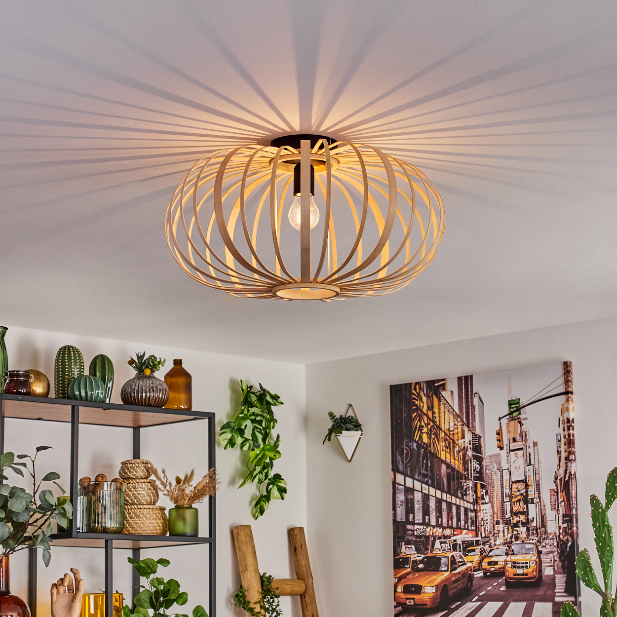 Eine Bambuslampe hängt von der Decke und wirft Schatten. Der Raum hat Pflanzen, ein Gemälde einer Stadt und andere Dekorationen.