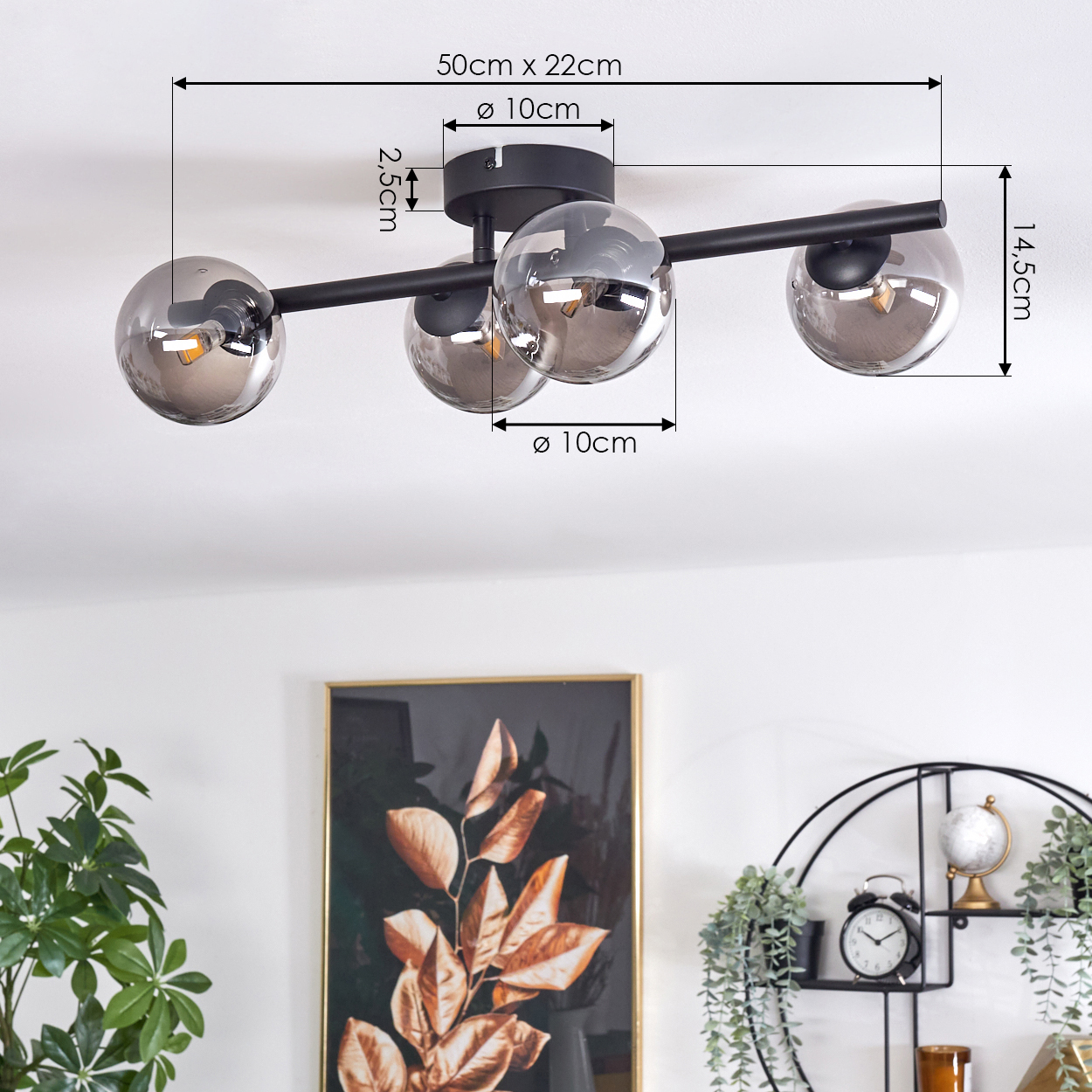 Eine Deckenlampe mit drei verchromten Kugeln, Abmessungen angegeben. Die Lampe hängt von einer weißen Decke ab. Innenraum.