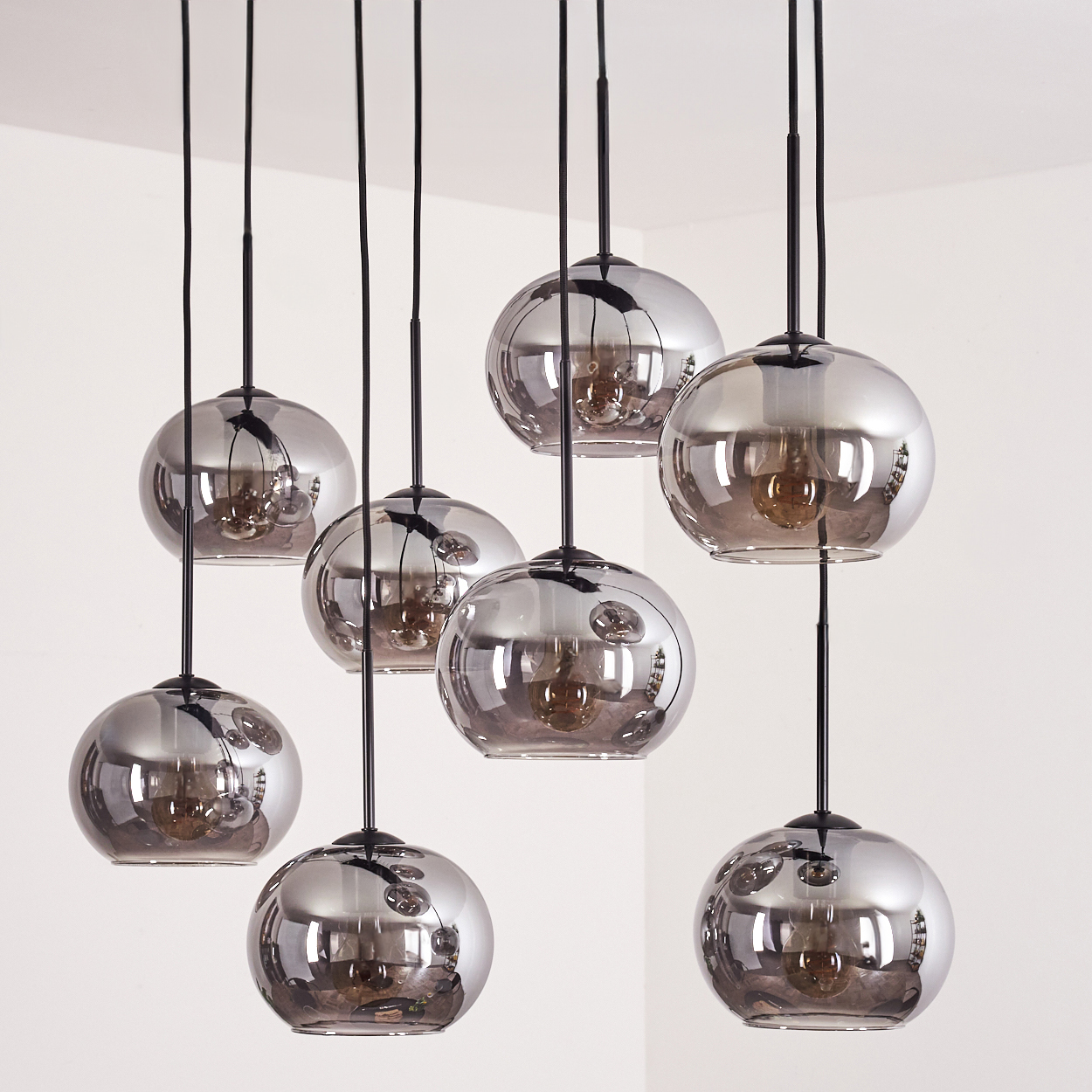 Sieben Kugelleuchten hängen von der Decke. Die Lichter haben eine reflektierende Oberfläche.