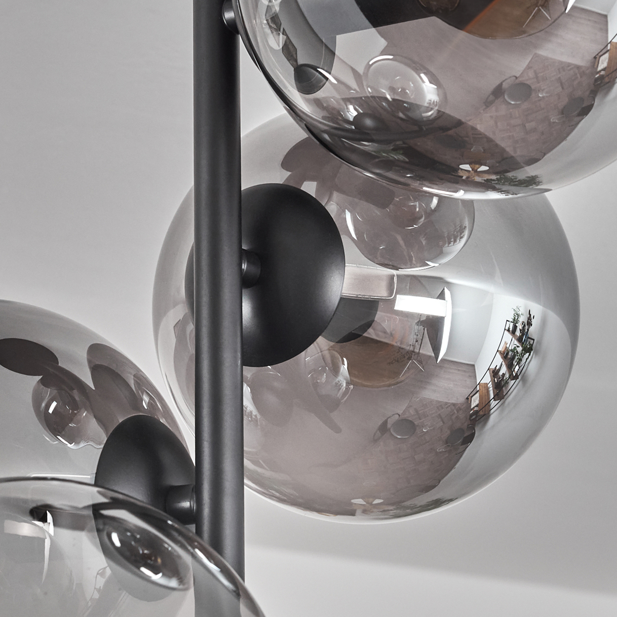 Nahaufnahme mehrerer Glaskugellampen. Die Kugeln spiegeln die Umgebung wider.