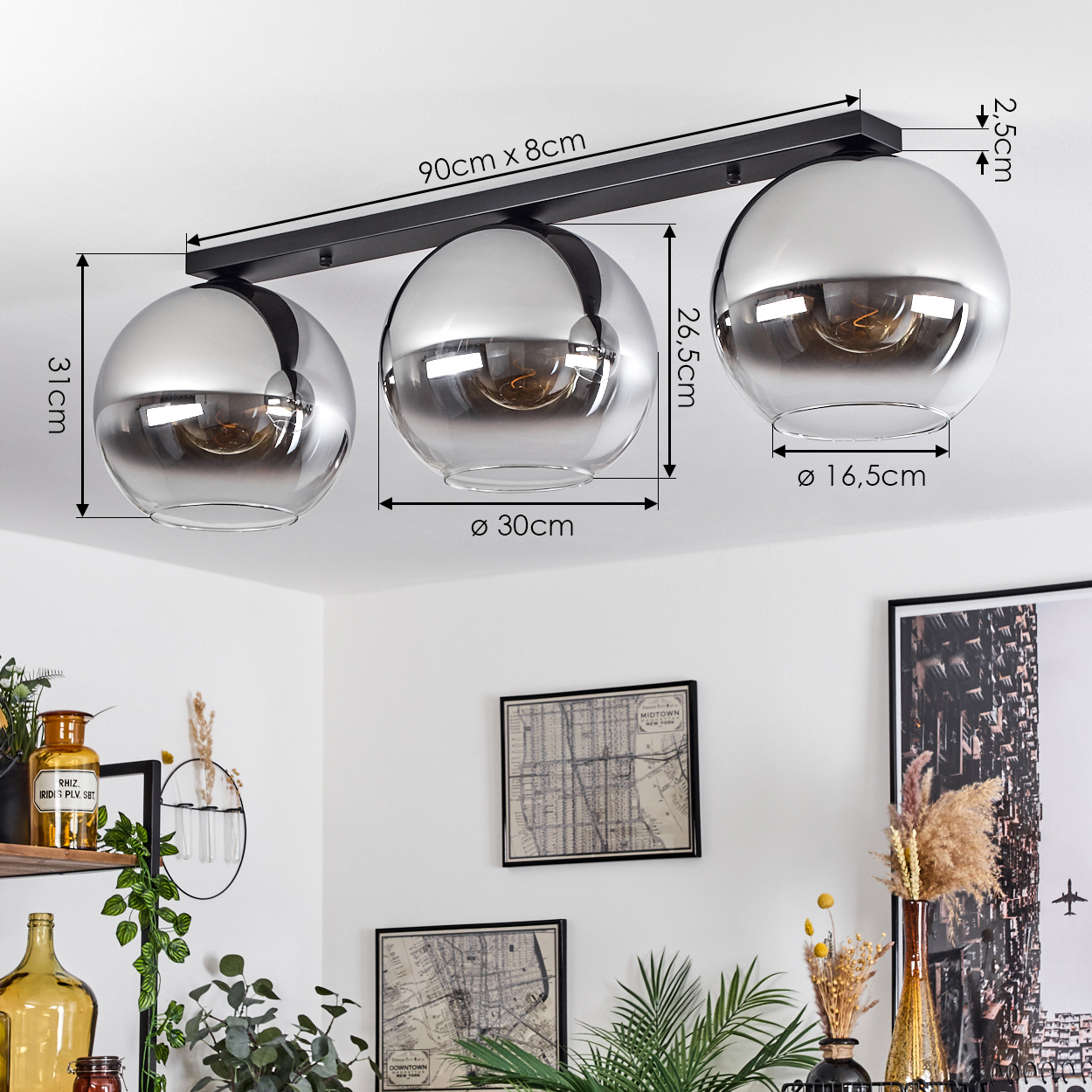 Eine Deckenlampe mit drei Glaskugeln, mit angegebenen Abmessungen. Die Lampe ist an einer schwarzen Stange befestigt.