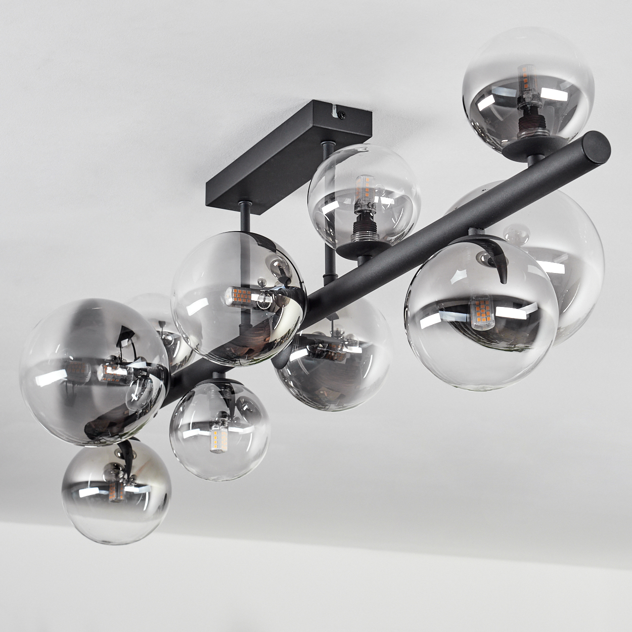 Deckenleuchte mit 10 Glaskugeln. Die Kugeln sind klar mit metallischem Finish. Weiße Decke.
