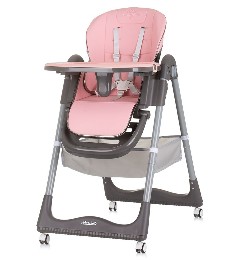 Silla alta para bebé rosa y gris. Tiene una bandeja, correas de seguridad y ruedas. Fondo blanco.