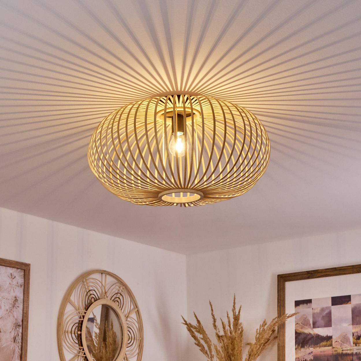 Deckenleuchte aus Holz. Es hat eine ovale Form mit vielen vertikalen Stäben. Weiße Decke.