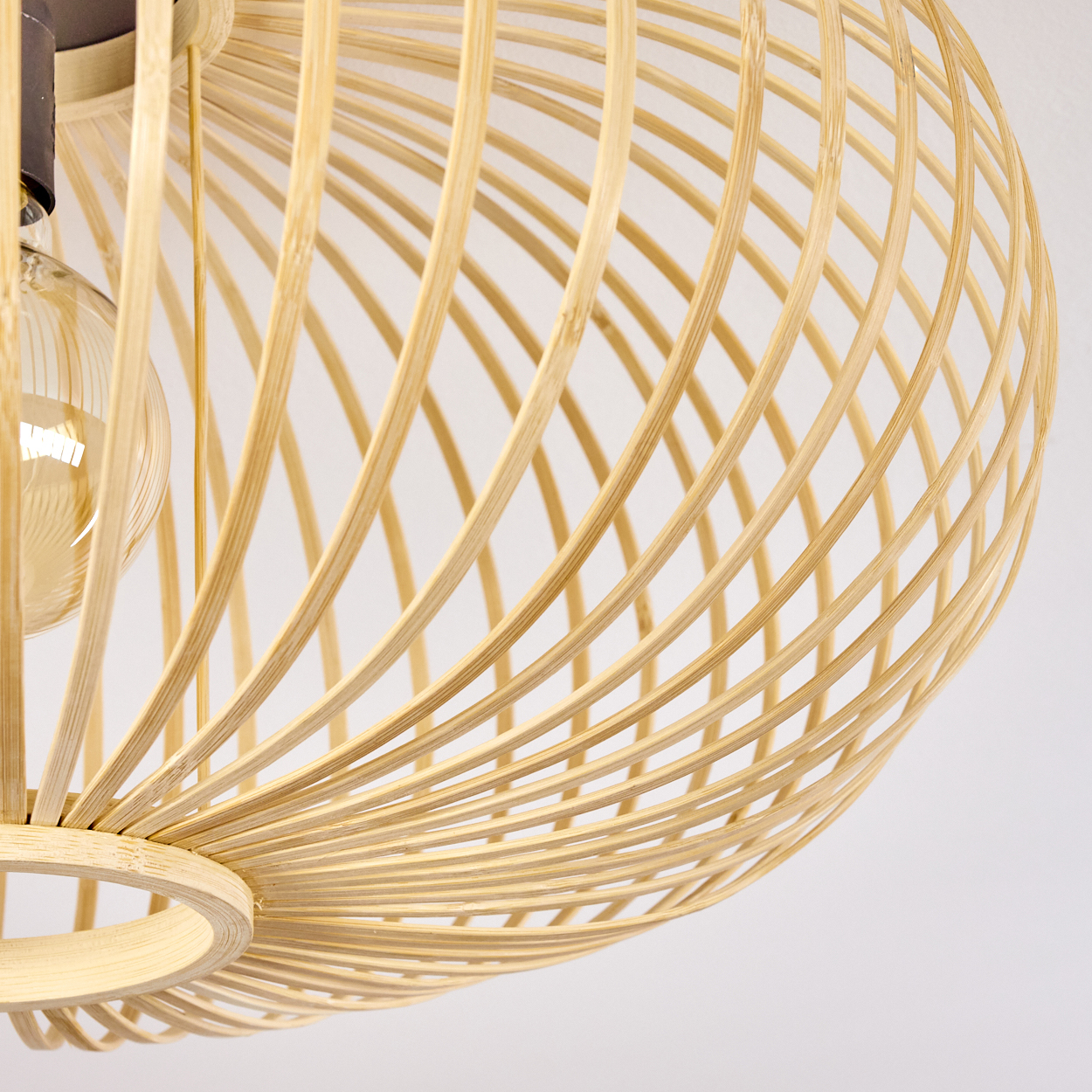Nahaufnahme der Bambus-Deckenlampe. Die Struktur und die Glühbirne sind sichtbar.