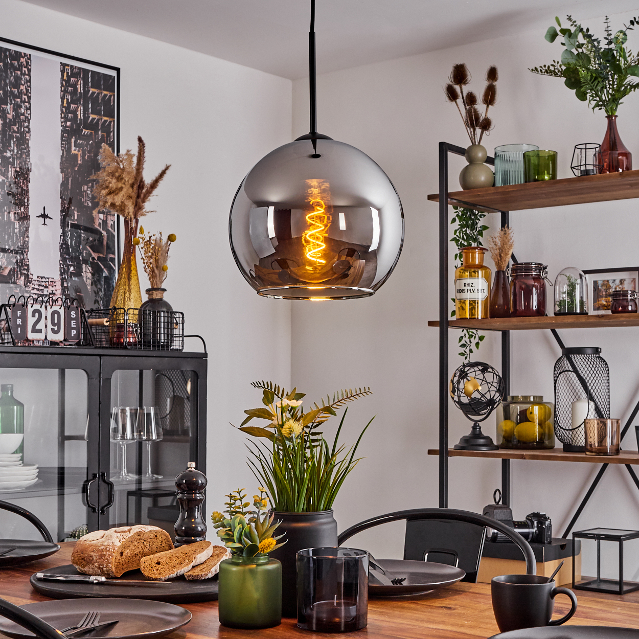 Esszimmer mit Tisch und Pendelleuchte. Eine Chromkugellampe hängt über dem Tisch.