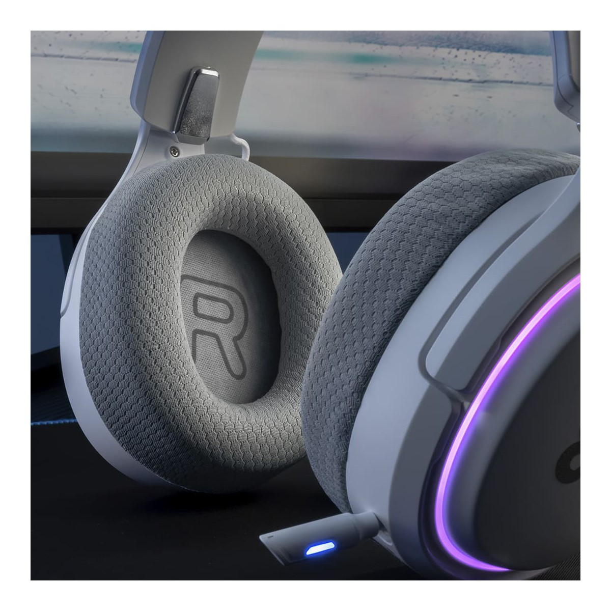 Zbliżenie białego zestawu słuchawkowego dla graczy, pokazujące nausznik i mikrofon.