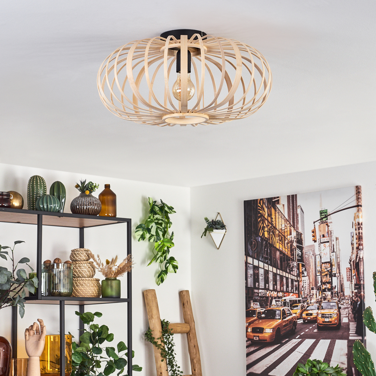 Eine hölzerne Leuchte, die von der Decke hängt. Ein Stadtlandschaftsbild und Pflanzen im Hintergrund.