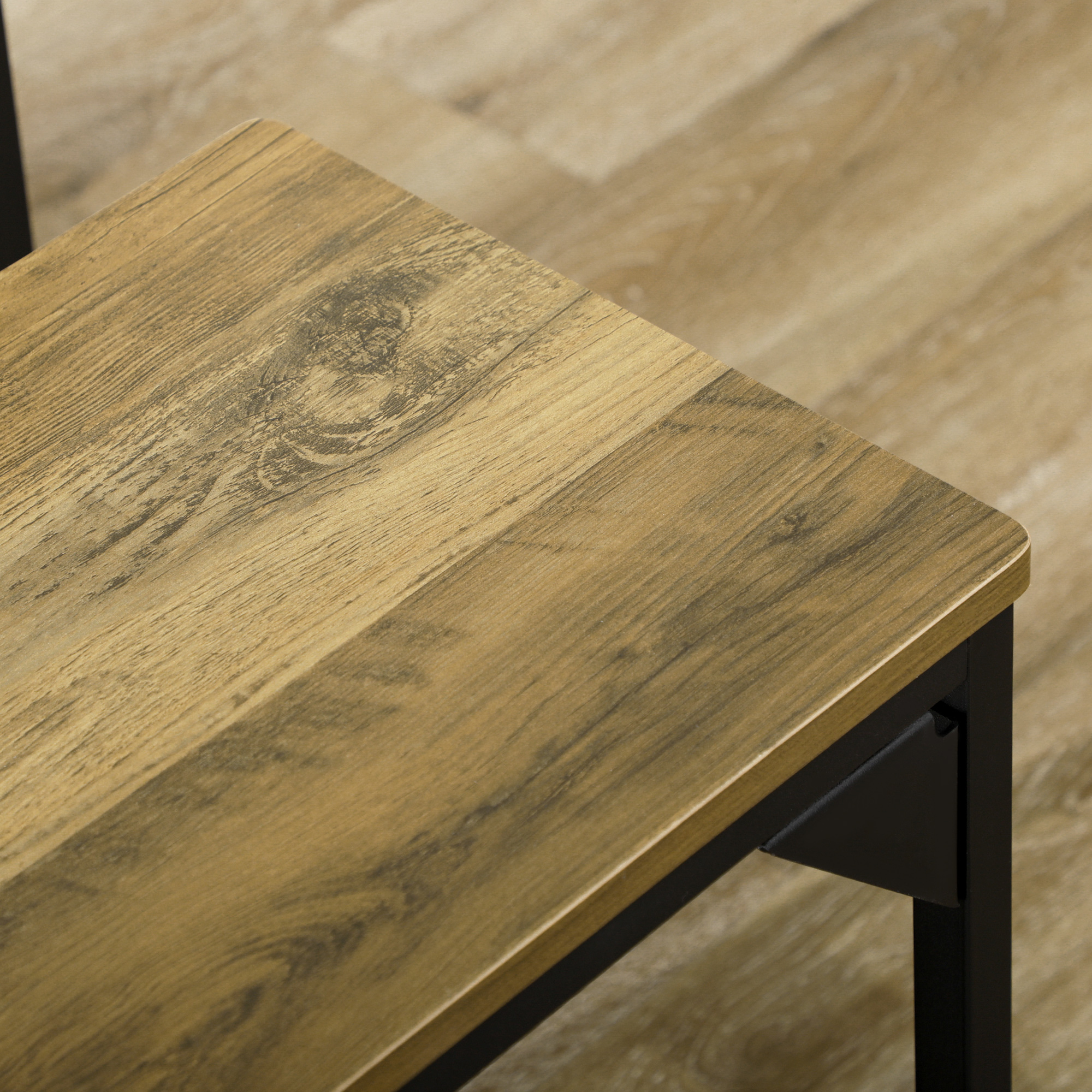 Nahaufnahme einer Holz-Tischoberfläche mit schwarzen Metallbeinen. Das Holz hat eine natürliche Maserung.