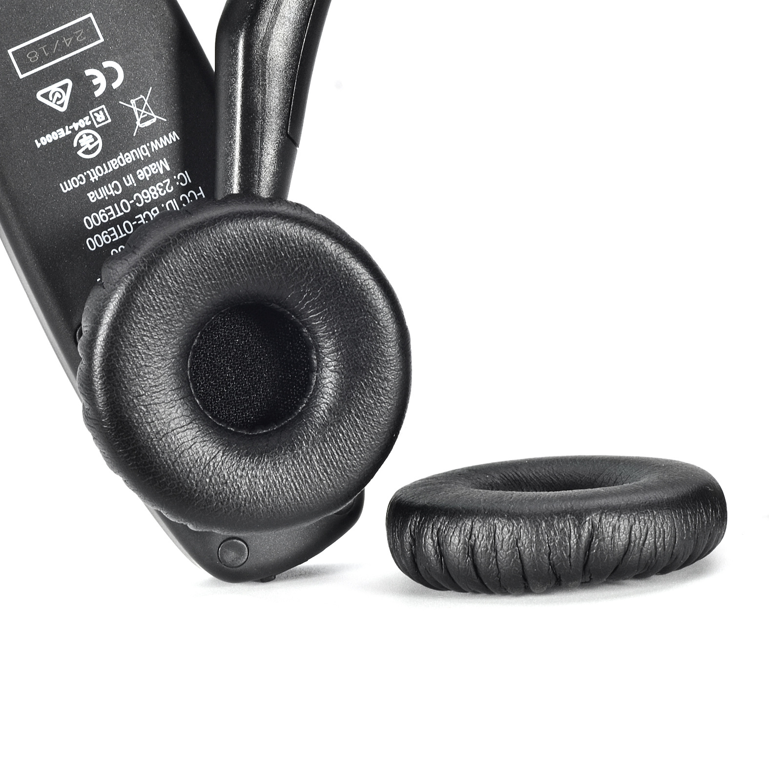 Ein schwarzes Headset mit abgenommenem Ohrpolster. Das Polster ist schwarz mit einem Mesh-Mittelteil. Weißer Hintergrund.