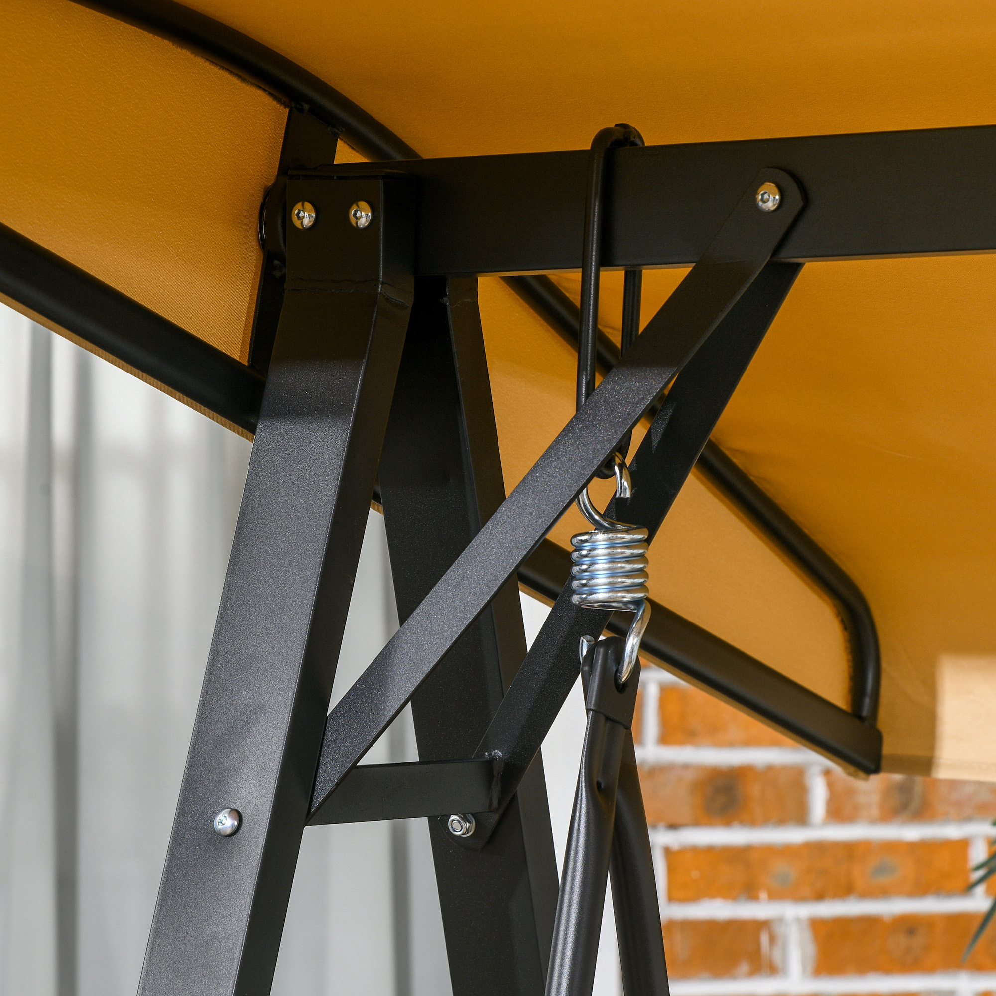 Nahaufnahme des schwarzen Metallrahmens und des beigen Baldachins eines Schaukelsets.