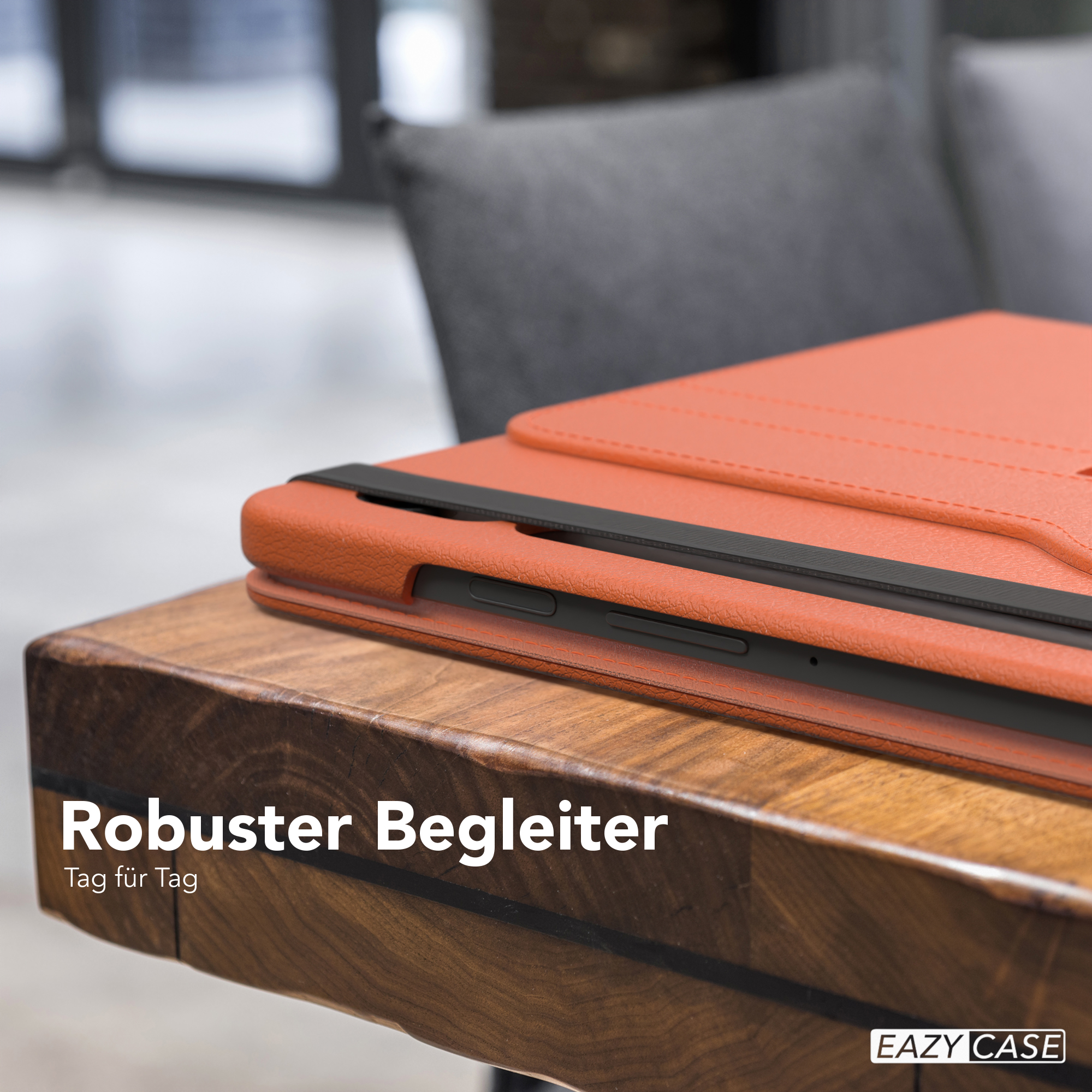 Nahaufnahme eines Tablets in einer orangefarbenen Hülle, das auf einem Holztisch liegt. Text sagt 'Robuster Begleiter'.