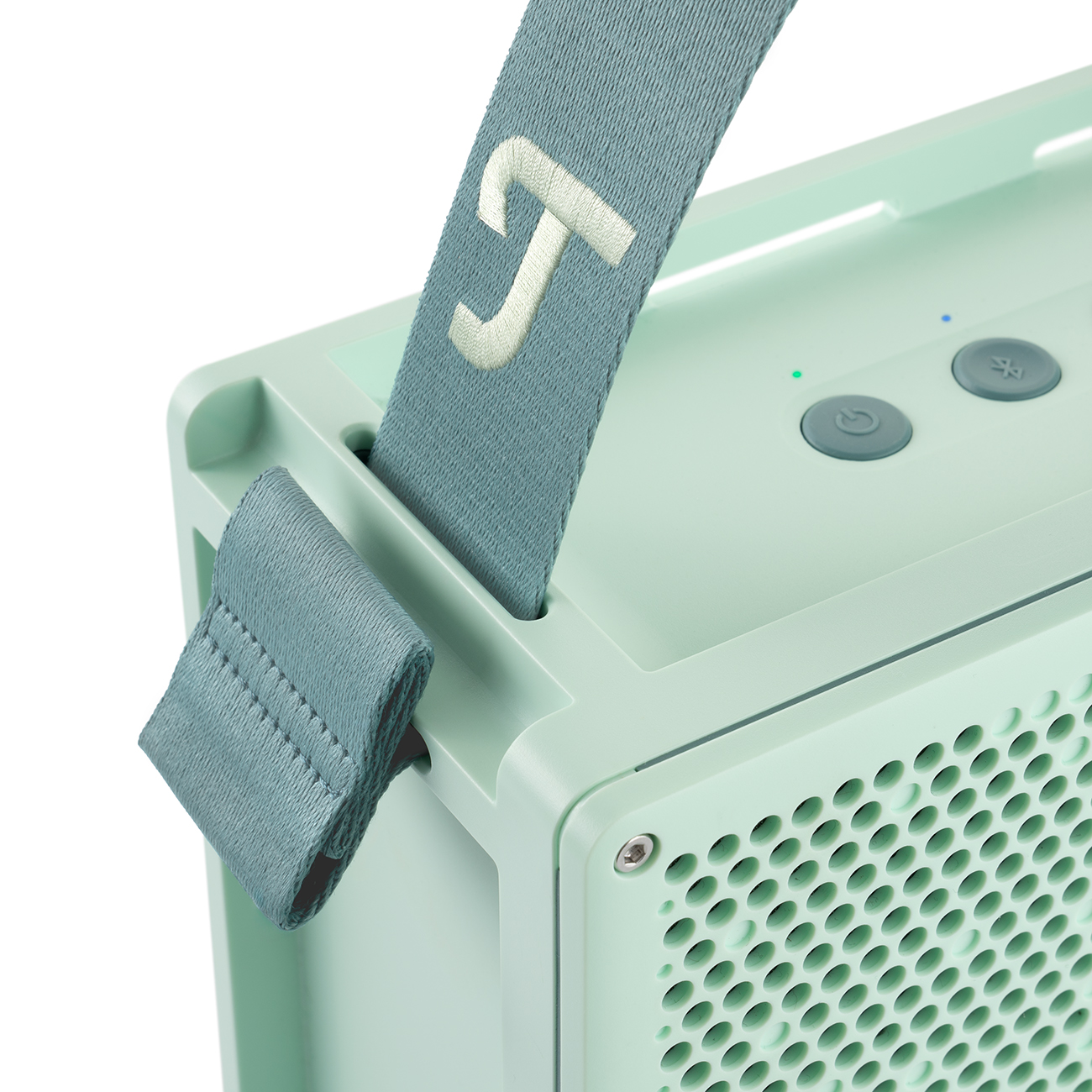 Gros plan sur la poignée d'un haut-parleur Teufel vert menthe. Le haut-parleur est visible à l'arrière-plan.
