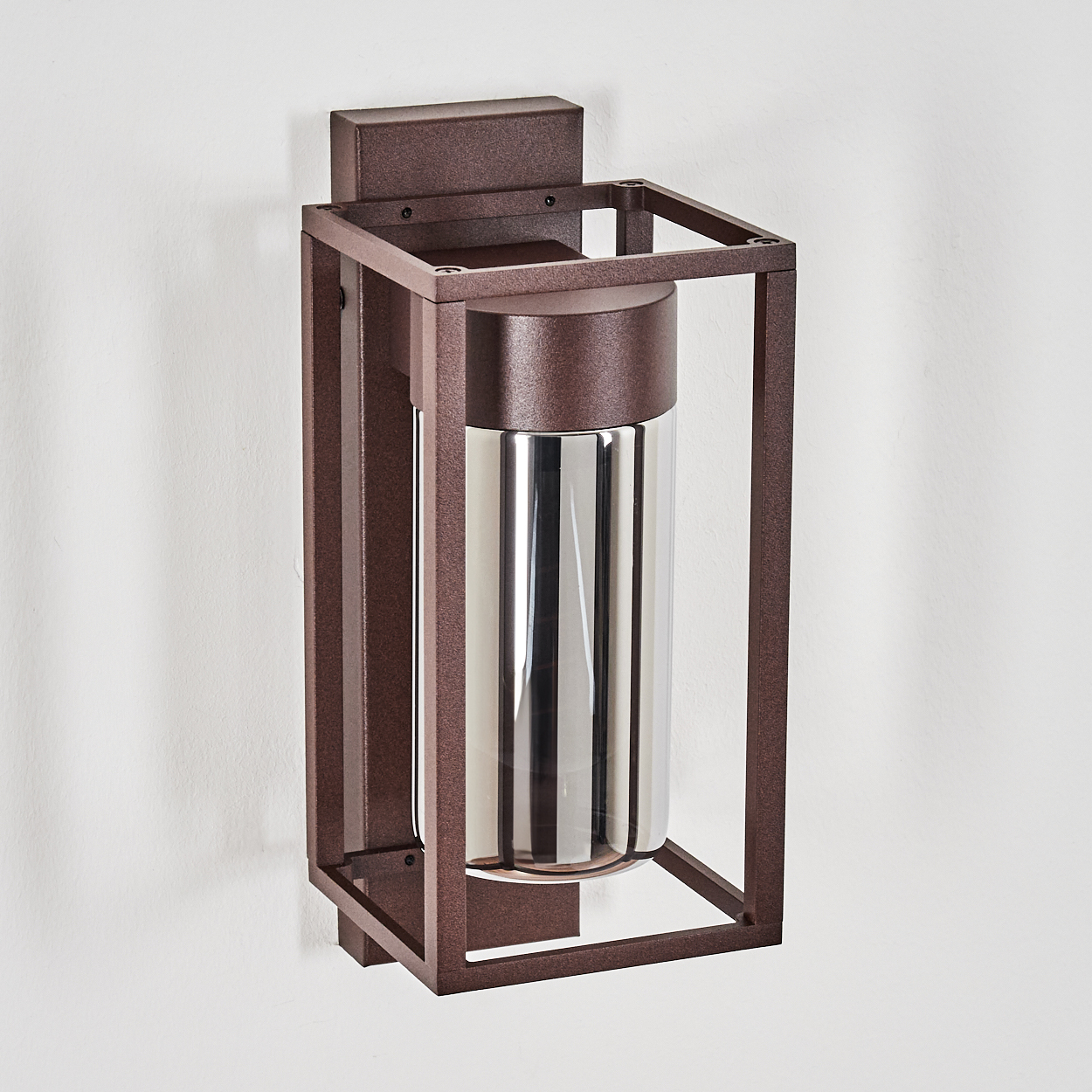 Eine braune Wandleuchte mit rechteckigem Rahmen und zylindrischem Glasschirm. Sie ist an einer weißen Wand befestigt.