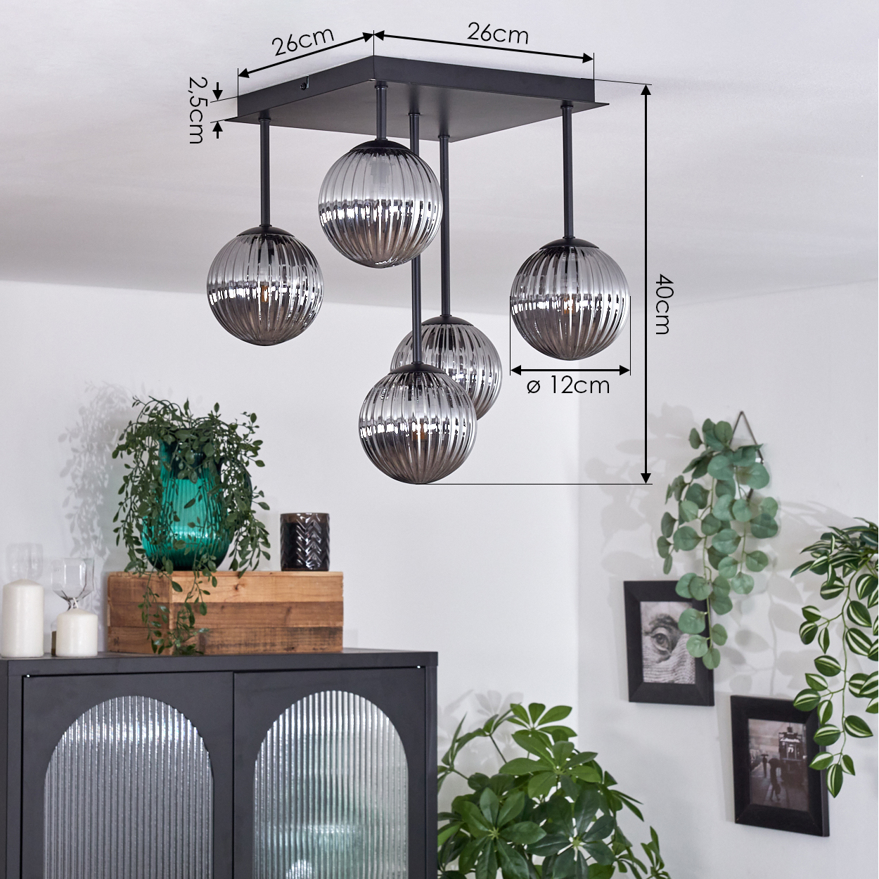 Fünf Lampen hängen an einer schwarzen, quadratischen Deckenhalterung. Jede Lampe hat einen gerippten Glaskolben. Der Hintergrund ist weiß.