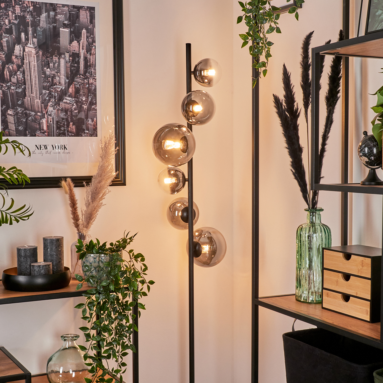 Stehlampe mit sechs Kugelleuchten. Sie steht in einem Raum mit Regalen, Pflanzen und einem New York-Bild.