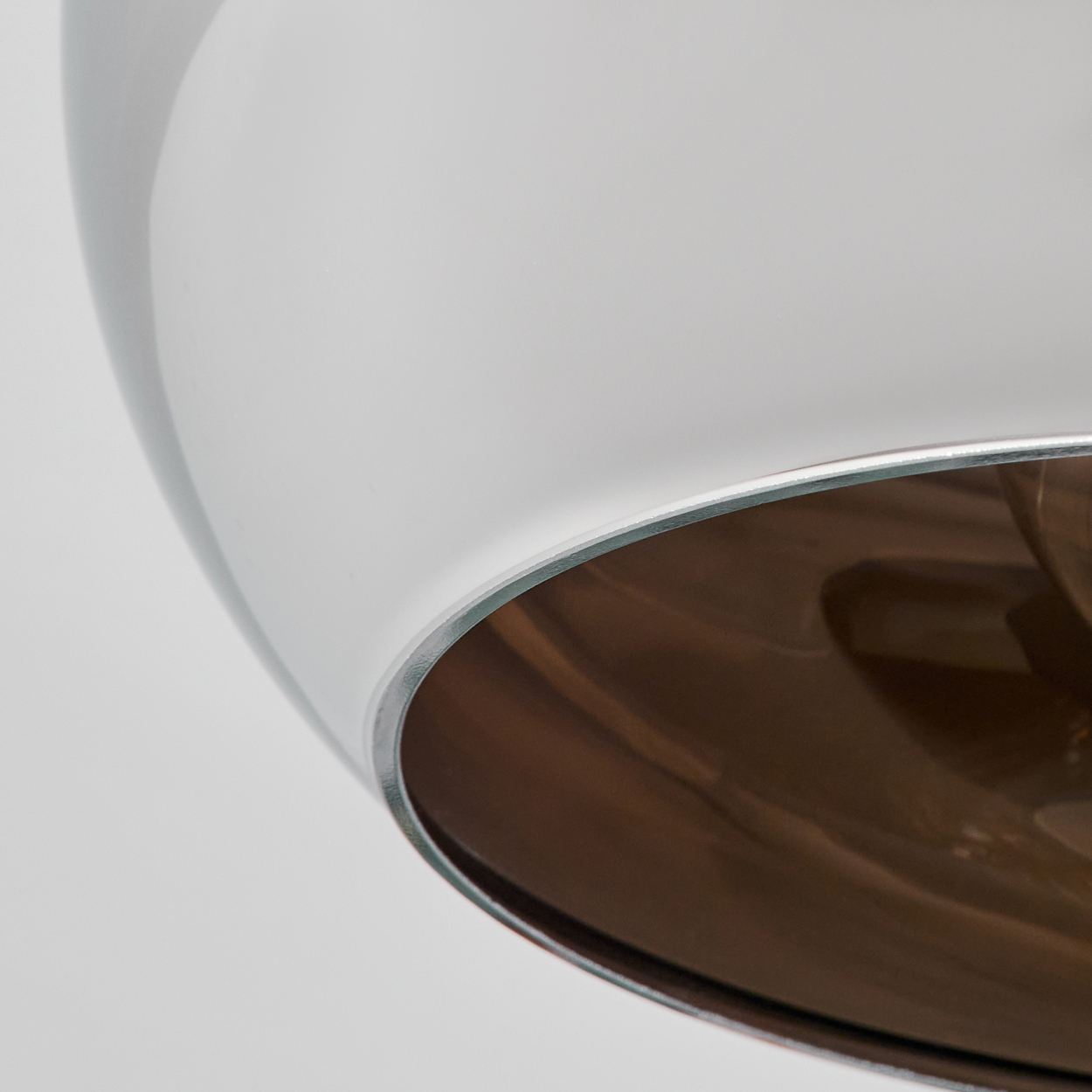 Nahaufnahme der Chrom-Deckenlampe. Die Innenseite ist braun.