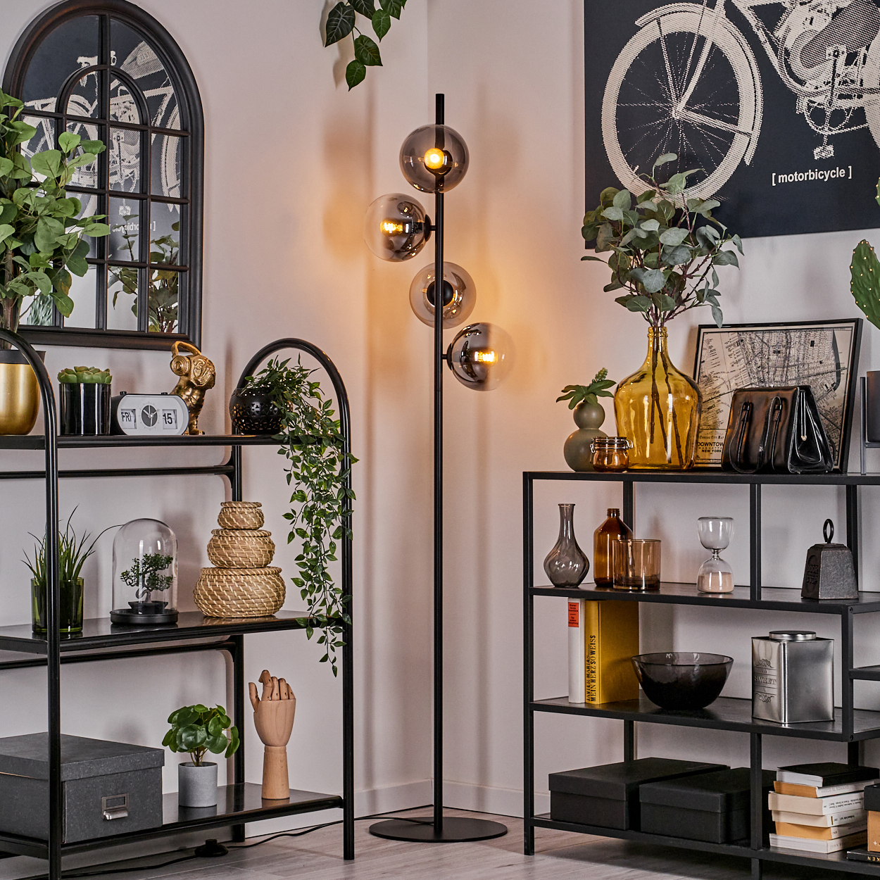 Eine Raumecke mit Stehlampe, Regalen und dekorativen Gegenständen, beleuchtet durch das warme Licht der Lampe.