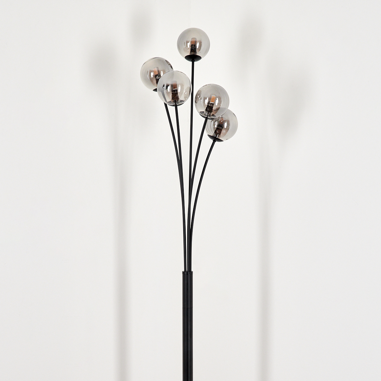 Stehlampe mit mehreren gebogenen Stielen, je mit rundem Glasschirm und sichtbarer Glühbirne.
