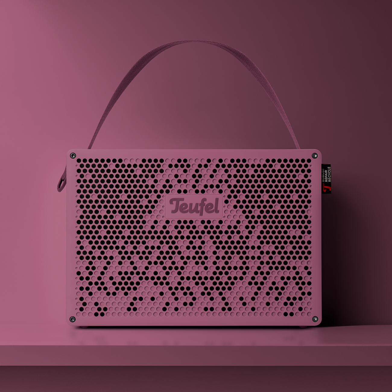 Un haut-parleur violet avec un logo et une poignée. Il est sur une étagère avec un fond sombre.