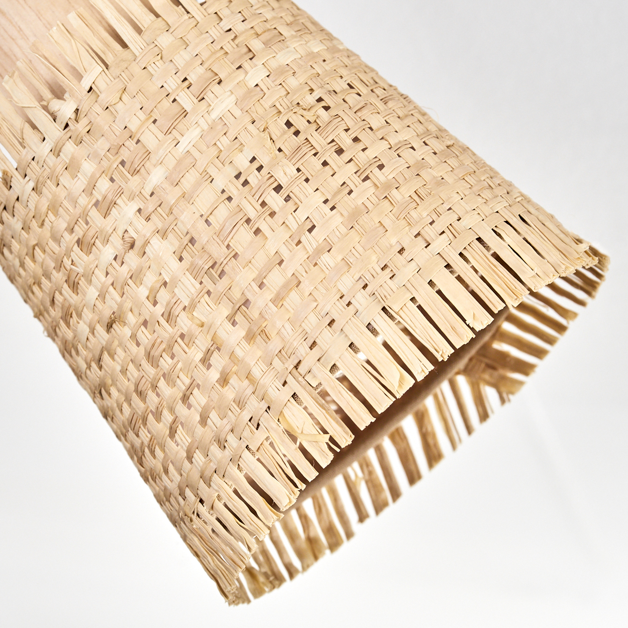 Nahaufnahme eines Lampenschirms aus Rattan mit gewebtem Muster. Die Textur ist sichtbar.