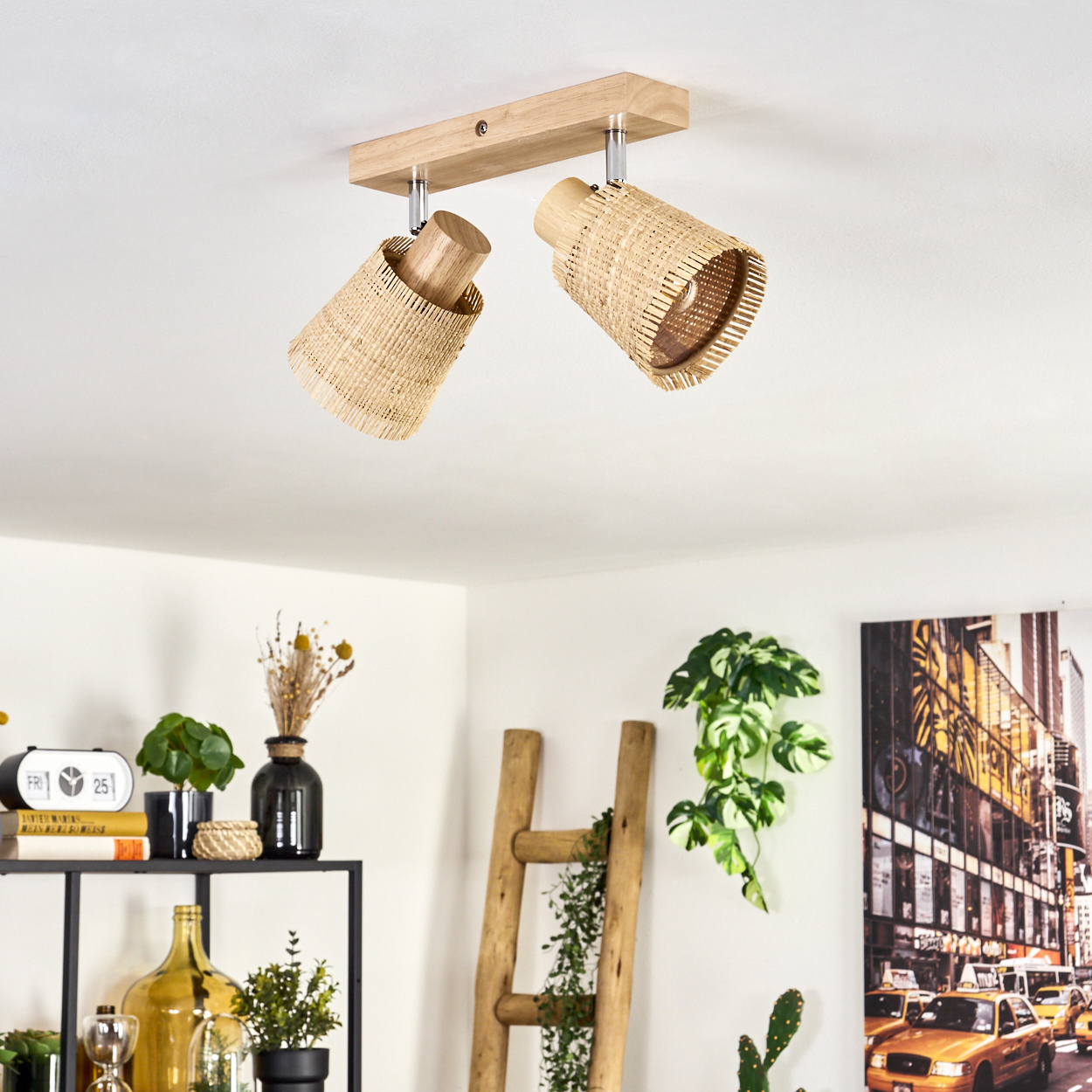 Eine Deckenlampe mit zwei gewebten Schirmen, die in einem Raum mit Dekoration, einschließlich einer Leiter und Pflanzen, hängt.