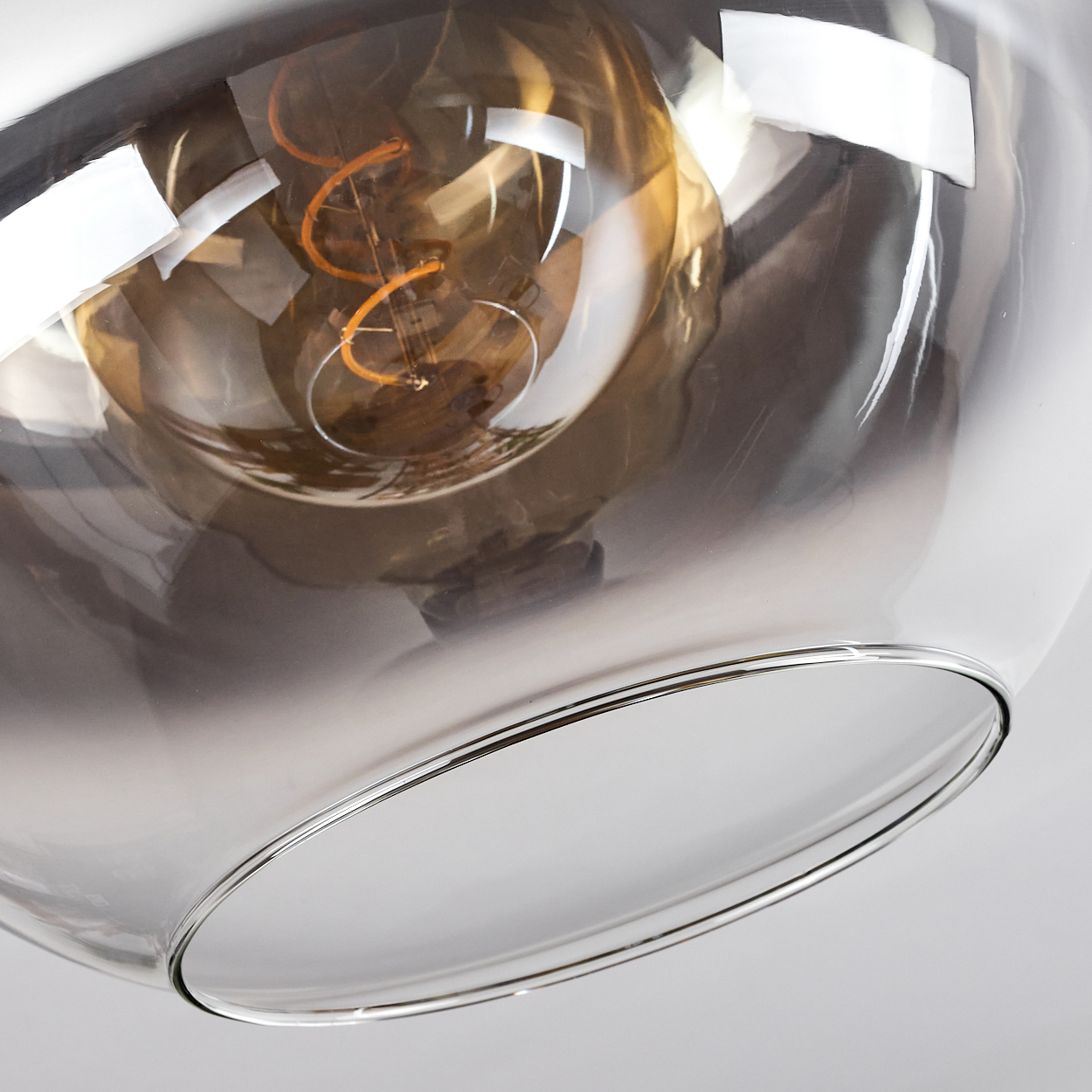 Nahaufnahme eines transparenten Glasschirms mit sichtbarer Glühbirne. Die Farbe ist braun.