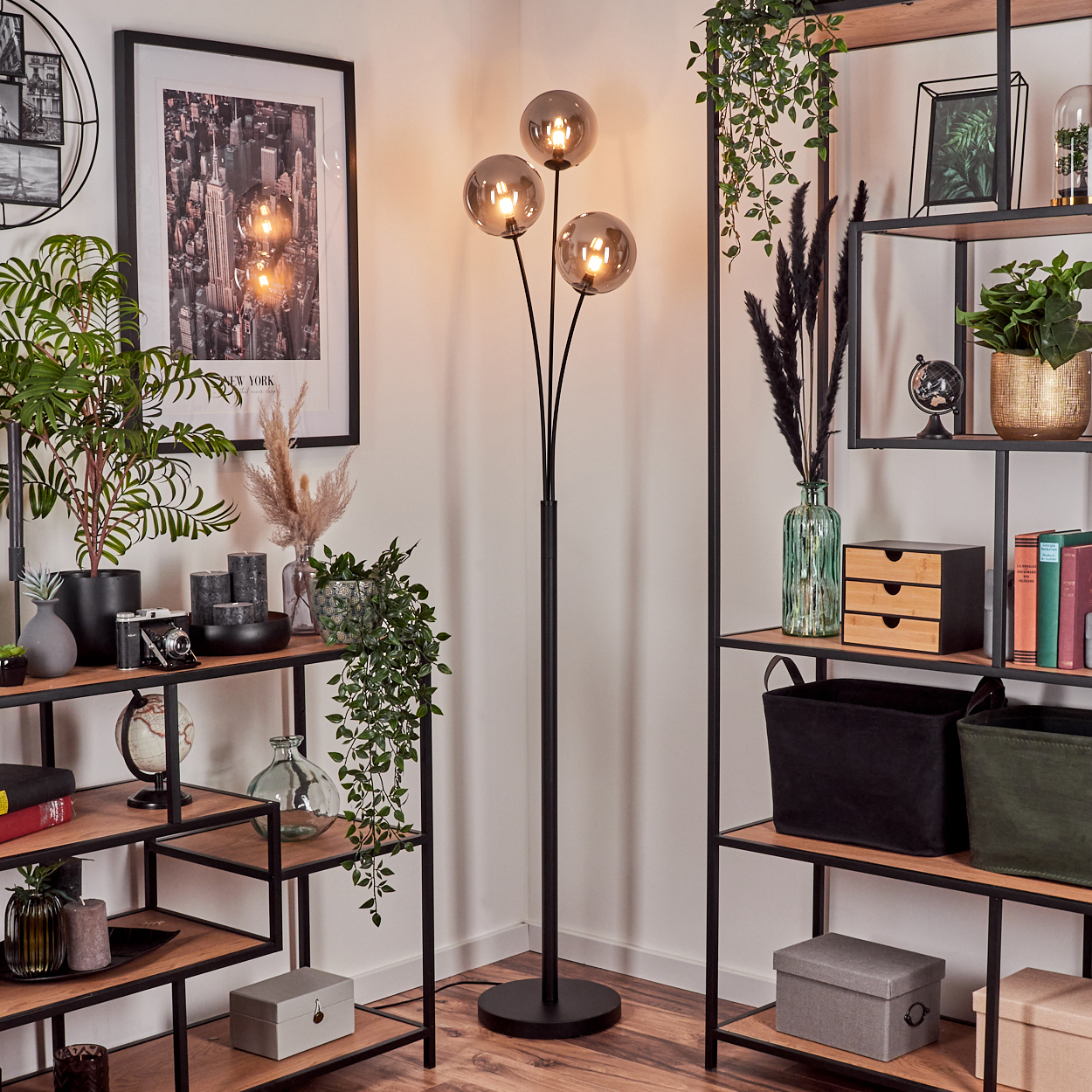 Eine Zimmerecke mit Stehlampe und Regalen. Das Zimmer ist dekoriert.