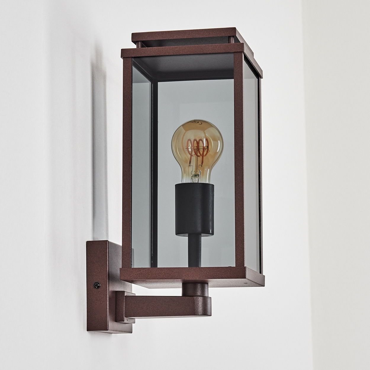 Eine Wandleuchte für den Außenbereich mit braunem Rahmen, Glasscheiben und sichtbarer Glühbirne.