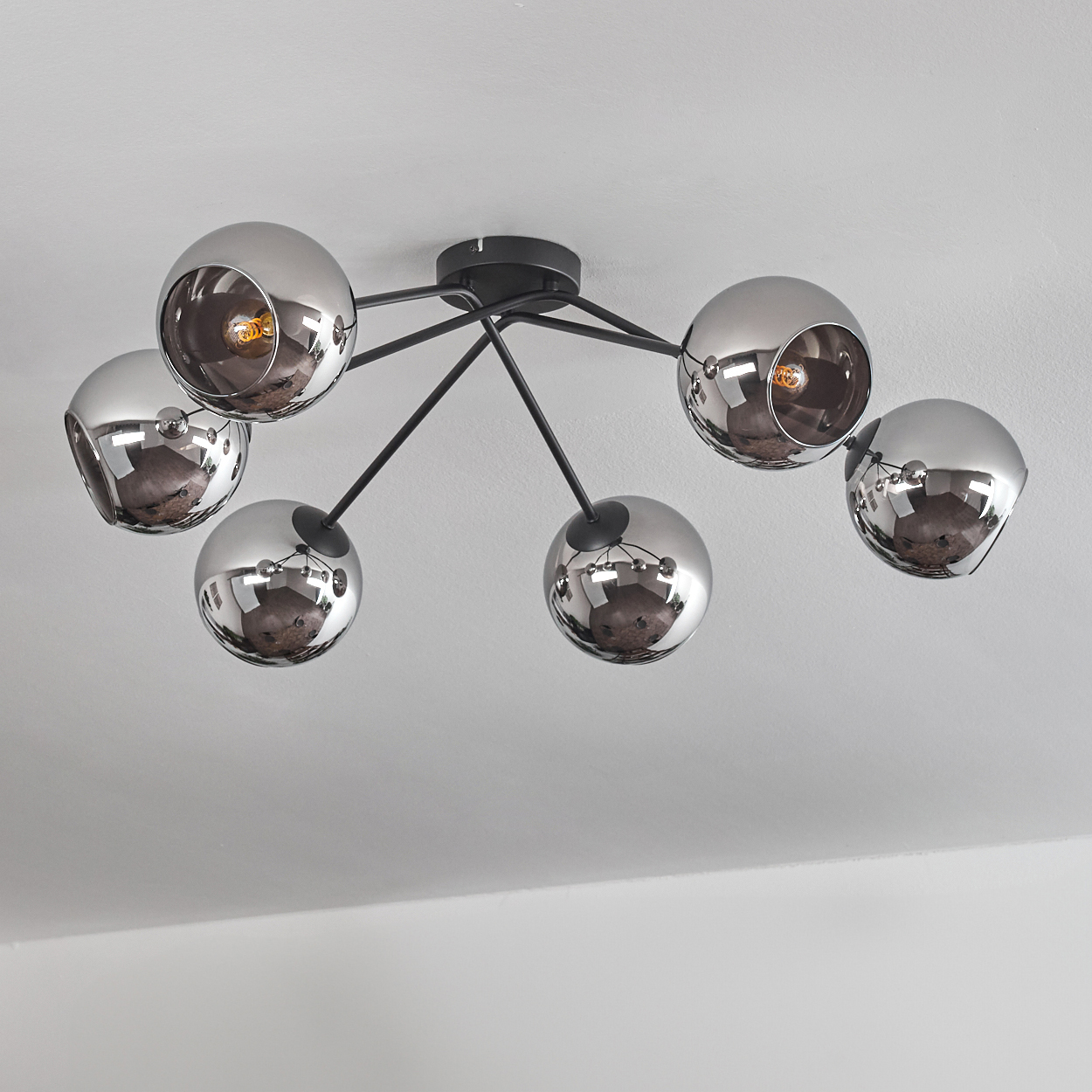 Eine Deckenleuchte mit sechs silbernen Kugellampen. Die Lampen sind um einen zentralen Stiel angeordnet.