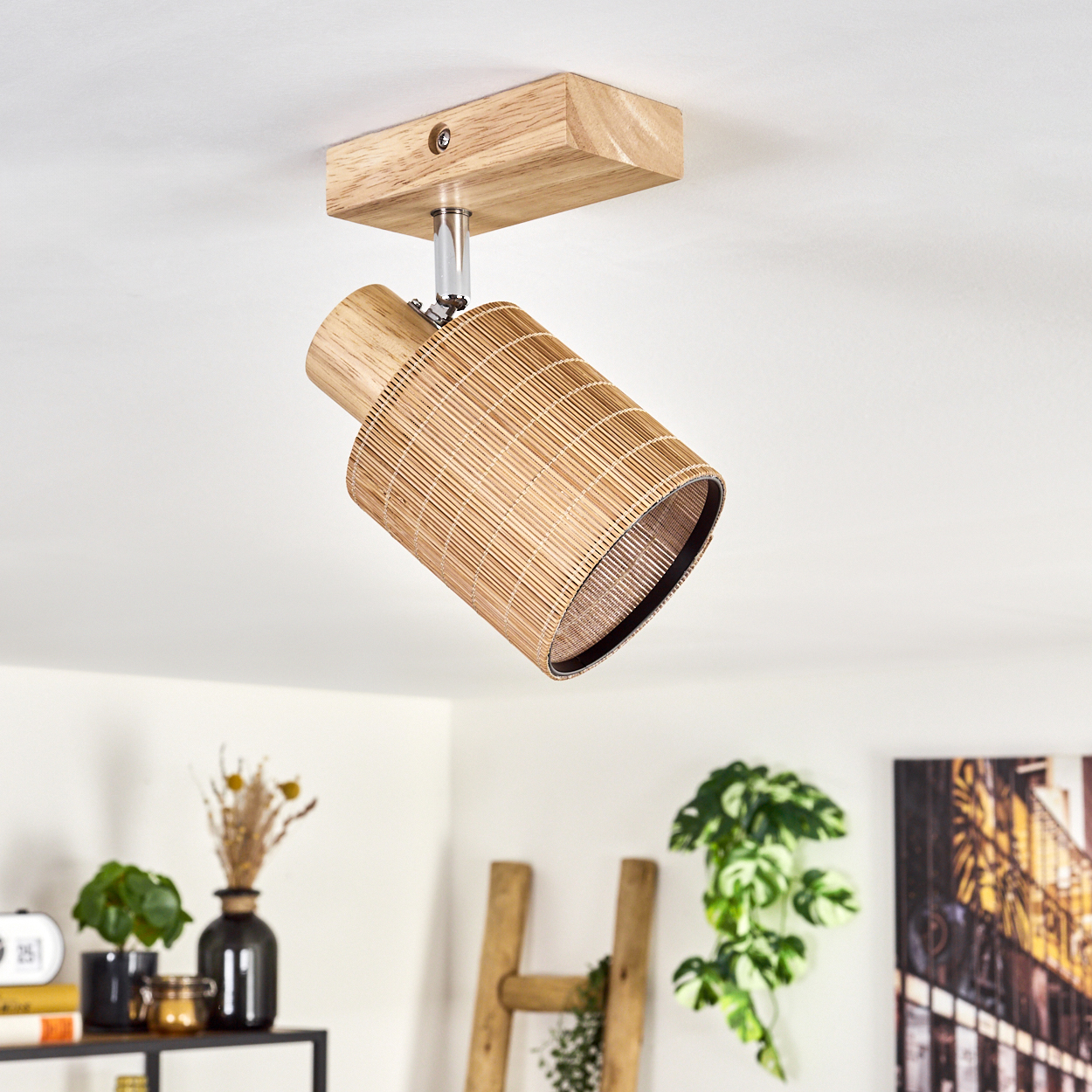 Eine Holz- und Web-Leuchte. Sie ist an der Decke in einem Raum mit Dekoration und Pflanzen montiert.